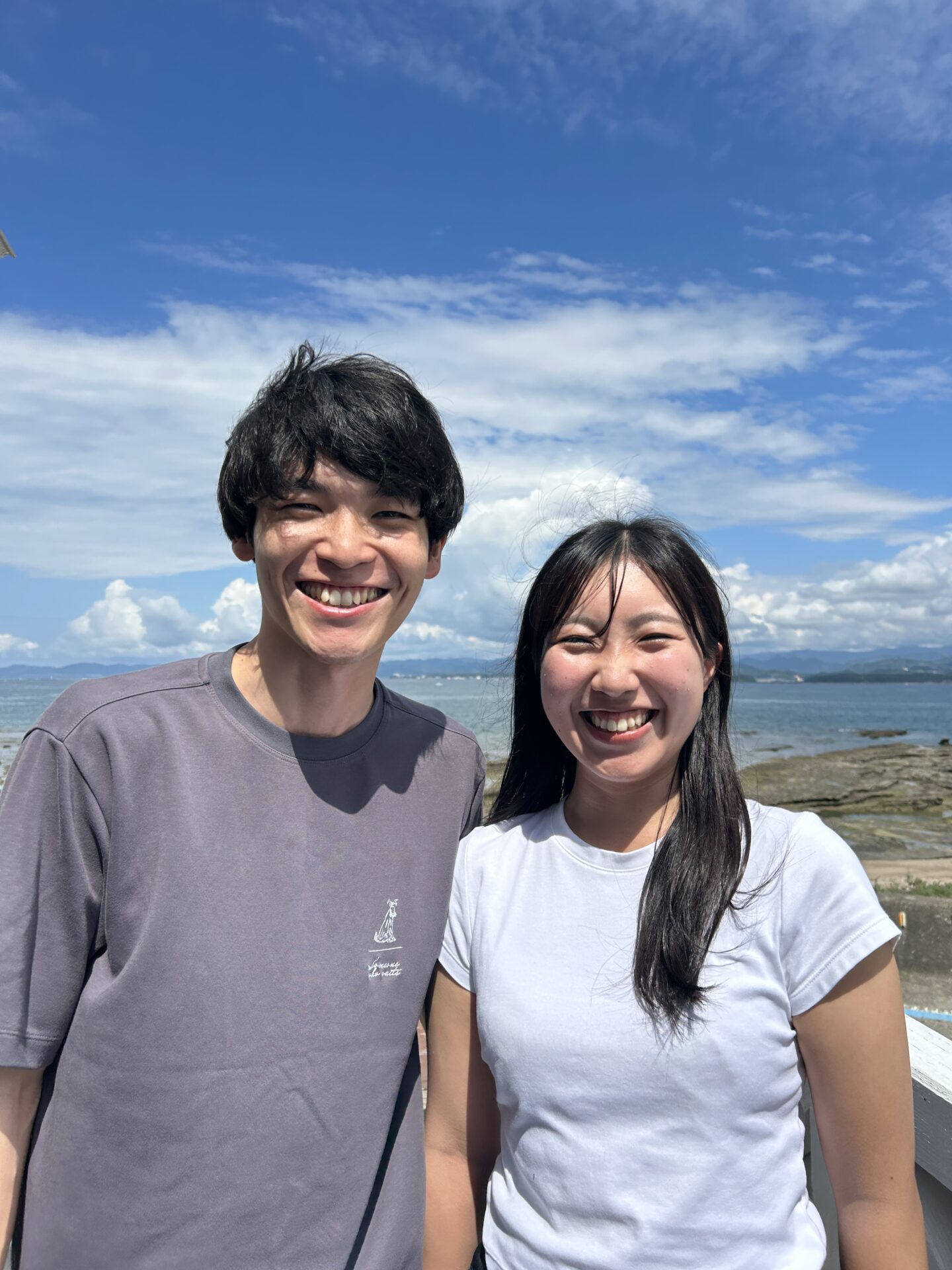 白浜の海を背景に笑顔のお二人