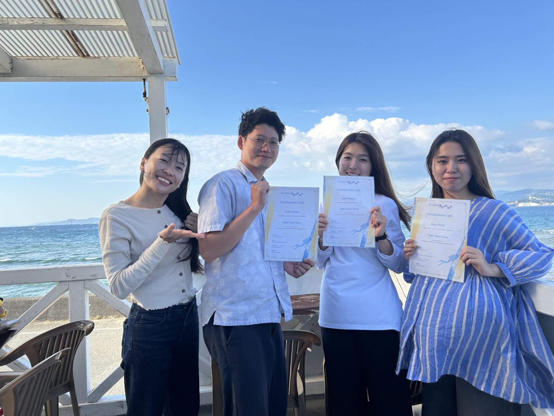 白浜の海をバックに4人で記念撮影